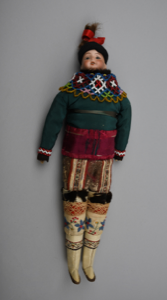 Image of Doll dressed in women's Greenlandic costume of sealskin pants and overblouse, beaded collar
