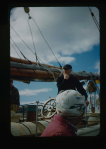 Image of Donald MacMillan on deck. Eskimo [Inuk] woman in foreground