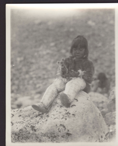 Image of Shoo-e-ging-wah [Suakannguaq Qaerngaaq] with flowers [Young Inuit girl holding  Arctic poppies]