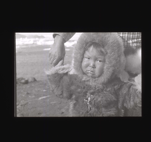 Image of Young Inuit girl weaing furs and wooden-bead pin  [b&w]