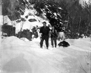 Image of [Donald MacMillan and ? hauling equipment in snowy woods]