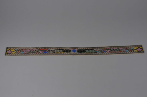 Image: Belt beaded in multi-color floral pattern with black and white border.