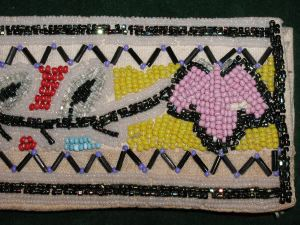 Image: Belt beaded in multi-color floral pattern with black and white border.