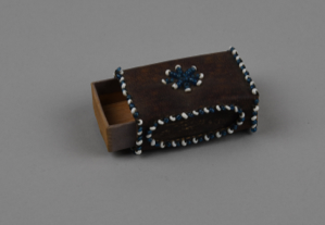 Image: brown leather matchbox cover with blue and white beads