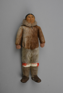 Image of female doll with dressed in sealskin hooded parka, breeches, and boots
