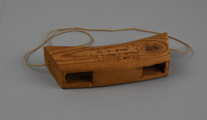 Image: Wooden snow goggles with string headpiece worn by Nap-A-Oo, a Nascopie Indian
