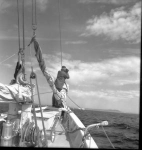 Image of Crewman watching iceberg with binoculars  at Battle Harbor