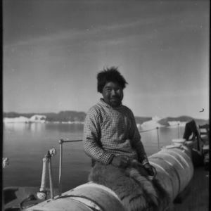 Image of Eskimo [Inuk] at rail, Inglefield Fjord