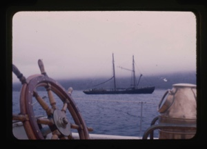 Image of whaling ship framed by wheel and compass