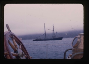 Image of whaling ship framed by whell and compass