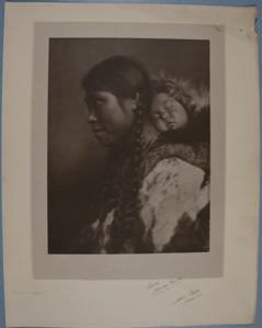 Image of North Alaskan adult female with braids, with baby in her hood