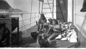 Image of Two Eskimo [Inuit] women, four children- on deck with pile of birds