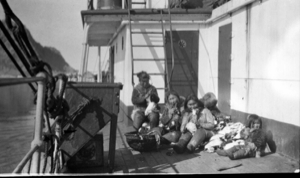 Image of Eskimo [Inuit] women and children on deck, chewing skins