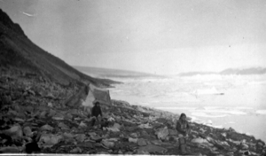 Image of Eskimos [Inuit] and tupik on rocky shore
