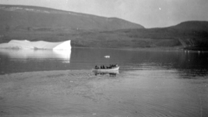 Image: Eskimos [Inuit] in an open boat; iceberg beyond