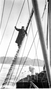 Image of Robert Bartlett  in long coat on rigging of "Beothic"