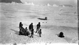 Image: Eskimo [Inuit] family with sledge. Igloo [iglu] being constructed in foreground