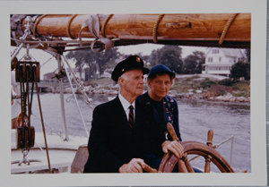 Image of Donald B. and Miriam MacMillan at the wheel of the Schooner Bowdoin. 