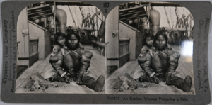 Image of stereo view card: Eskimo [Inuit] woman preparing a skin