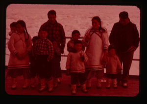 Image of Elllesmere Island Eskimos [Inuit] aboard the U.S.S. Atka to be checked by doctor.