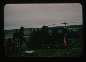 Image: Repairing jeep disabled from fine dust in engine. Helicopter beyond