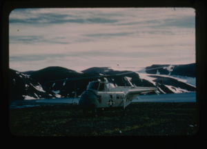 Image: Navy helicopter from U.S.S. Atka parked near mountains and small ice caps 