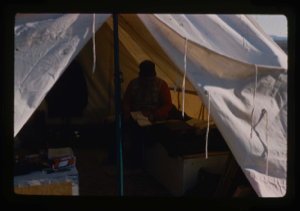 Image: Davies USGS completing field notes in sleeping tent at Polaris Promontory Site.