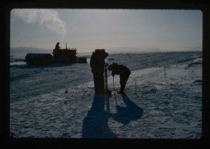 Image of Drilling hole for deflectometer tests on sea ice runway at Thule Bay. Bulldozer