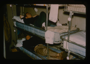 Image of Davies resting in bunk aboard the USS Atka prior to evening meal at Thule.