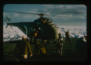Image of Helicopter from USS Atka returns to icebreaker after searching route thru ice