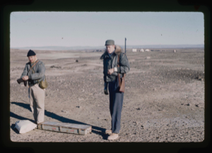 Image of Capt. Klick and Craven carry portable drill from base to core soil near runway