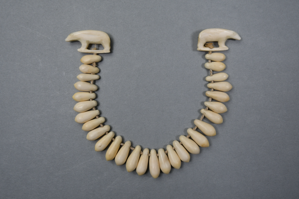 Image: Necklace w/tear-drop shaped segments and two small polar bears on each end.