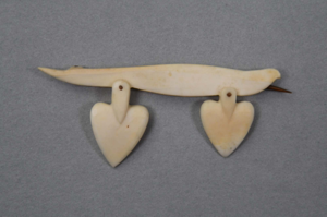 Image of Ivory pin with two heart shaped pieces dangling from the long ivory section
