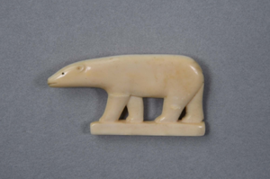 Image: Ivory polar bear pin with carved ear, mouth, and eye with feet on iceberg