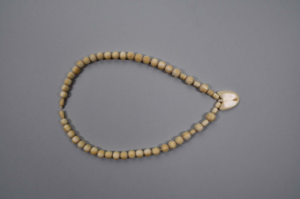 Image of Ivory necklace with 53 tubular-shaped beads, heart-shaped bead at center