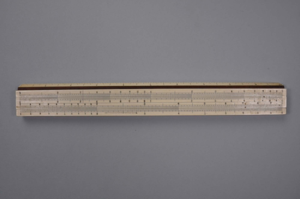 Image of Slide rule, marked with name MJ. Look and rulers in centimeters and inches