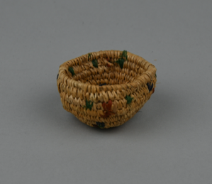 Image: Coiled basket with purple, green, red details inside/outside.
