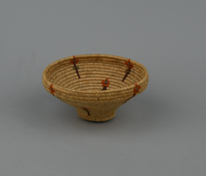 Image: Coiled grass basket with flower design, narrow base and wide top edge