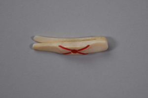 Image: Ivory clip with red cross inlay.