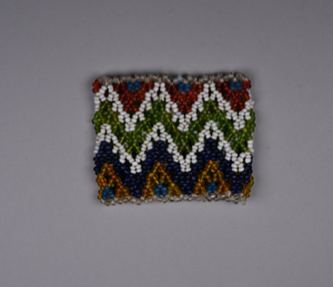 Image of Child's beaded cuff in blue, clear, orange, white, green, red in jagged pattern