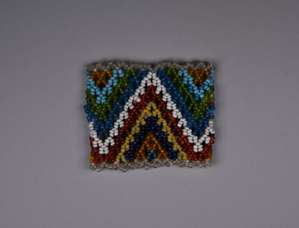 Image of Child's beaded cuff in clear, orange, blue, yellow, red, white, green jagged pat