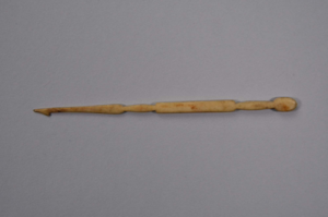 Image: Dark colored ivory crochet hook rounded at wide end, then oval shape, then recta