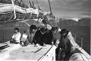 Image: Donald MacMillan and Eskimos [Inuit] reading charts on Schooner Bowdoin