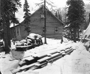 Image: MacMillan Scientific Station with snow on ground, lumber and other supplies