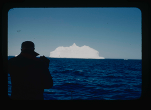 Image of Donald MacMillan photographing an iceberg