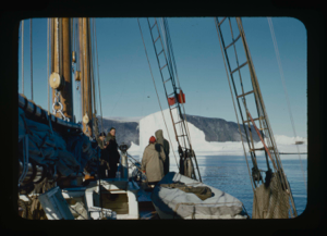 Image of The Bowdoin approaching an iceberg. Miriam MacMillan and crew  on deck.