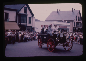 Image: Old fashioned car and passengers in parade
