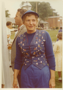Image: Miriam MacMillan wearing vest embroidered by Kate Hettasch, Don Lukens behind