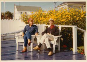 Image: Miriam and Donald MacMillan sitting on their terrace by yellow daisies
