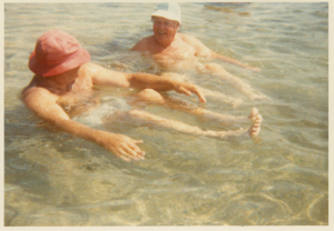 Image of Two men sitting in the water, hats on (Ed Morse?)
